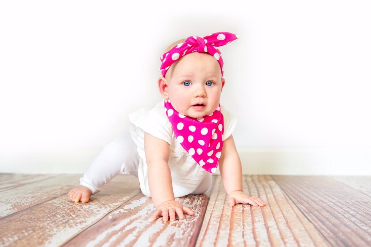 Toddler with hot pink headband and bib