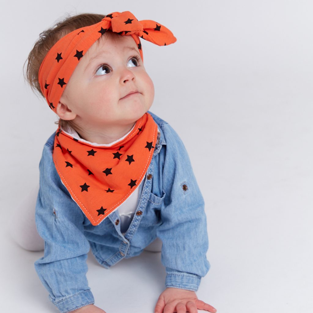Boy wearing orange star Frankie Lola bib and head wrap