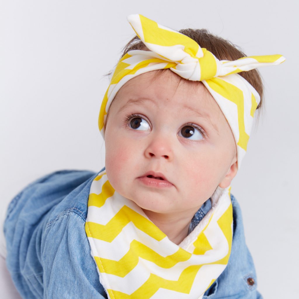 Boy wearing yellow & white chevy Frankie Lola bib and head wrap